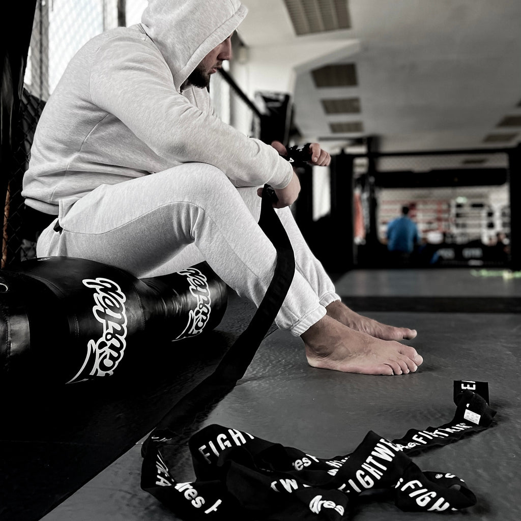 Kämpfer wickelt Ares Fightwear Boxbandagen im Gym vor dem Training